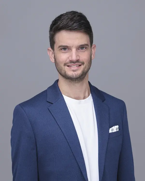 Businessportrait in Zug: Mann im dunkelblauen Sakko vor grauem Hintergrund